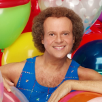 Fitness personality Richard Simmons surrounded by colorful balloons