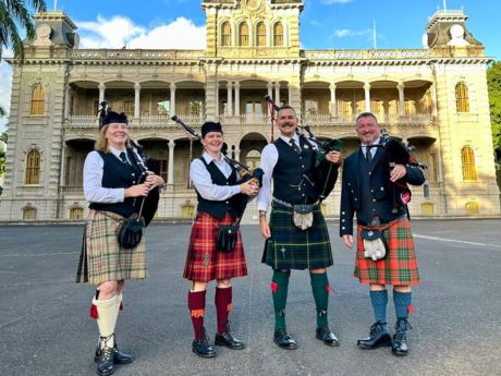 Four bag pipe players in front of Iolani Palace.