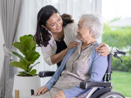 A female adult providing care to a wheelchair-bound female senior citizen