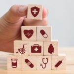A stack of ten wooden blocks with healthcare related images