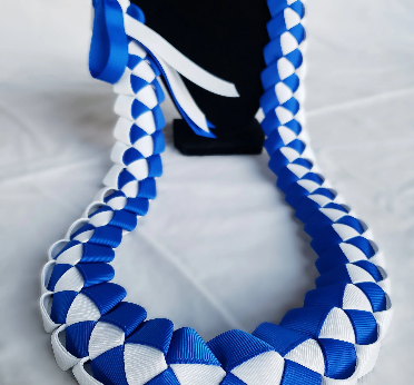 A blue and white ribbon lei on a gray background.