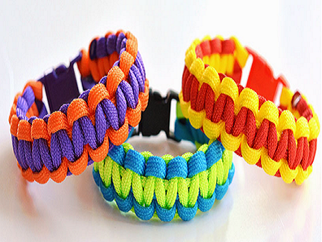 Colorful paracord bracelets on white table