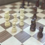 white and brown chess pieces on a chess board