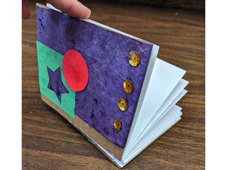 Hand made book being held open.