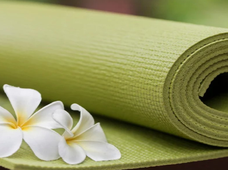 Image of a green rolled up yoga mat with plumerias
