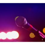 Image of microphone in front of pink neon lights.