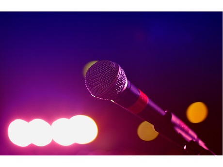 Image of microphone in front of pink neon lights.