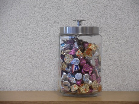 Image of clear jar with silver-colored cover filled with assorted individually wrapped pieces of candy