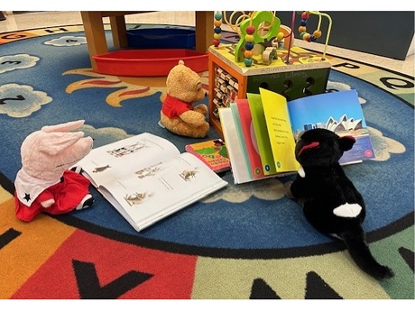 Stuffed animals reading books.