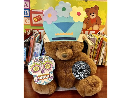 Teddy Bear modeling the following crafts: silly hat, sugar skull, and CD art.