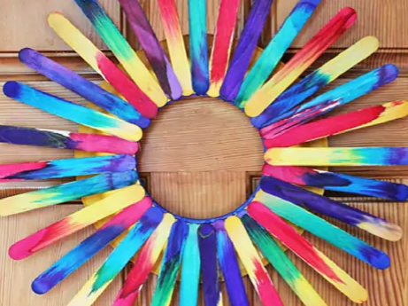 Craft sticks, painted in bright colors and glued into a sunburst.