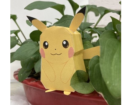 Paper Pikachu character nestled in houseplant