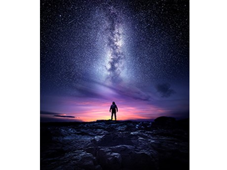 Silhouette of man at sunset with stars above