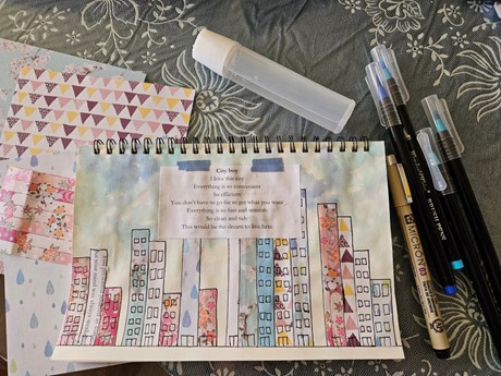 Journal with watercolor painted buildings and pens