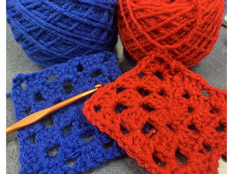crocheted granny squares with yarn and crochet hook