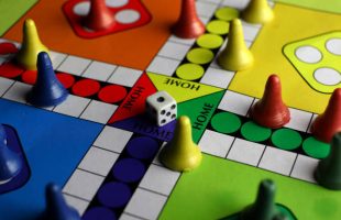 playing board games with dice, colorful board and pieces. red, blue, yellow and green. strategy games.