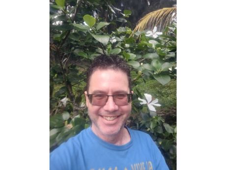 a man in front of a native hibiscus plant
