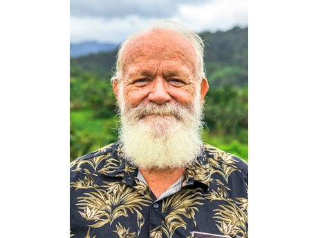 A portrait of an older gentleman with white beard and a blue and tan aloha shirt.