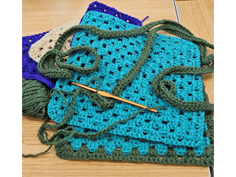 picture of two cerulean granny square with crochet hook