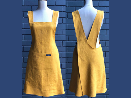 Yellow apron on a mannequin against a blue background
