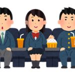 Three students wearing school uniforms watching a movie and eating snacks