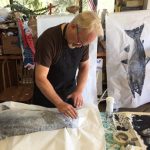 Male artist creating a gyotaku fish print.