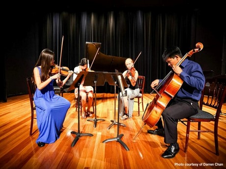 A group of four people playing string instruments