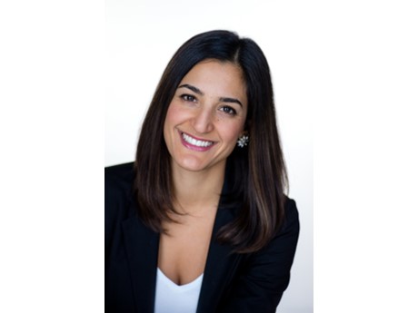 Headshot of smiling woman with straight brown hair wearing a white top and black blazer.