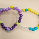 two bead bracelets, one in purple and lavender and one in yellow and mint green