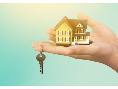 hands holding a tiny house and a key