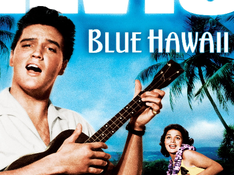 Elvis Presley plays ukulele on a beach with the words, "Blue Hawaii," next to him, and a lady in a bikini behind him.