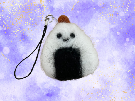 Onigiri key chain charm against a purple background