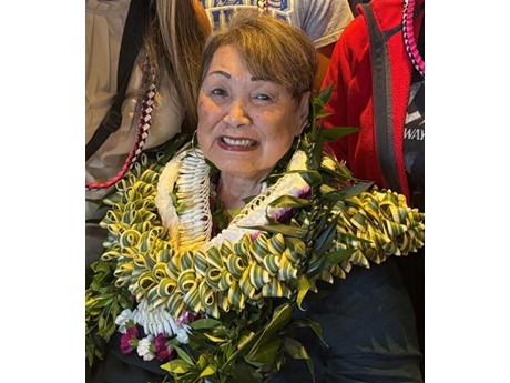 An older woman wearing multiple leis.