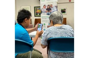 Teen helping kupuna with smart phone