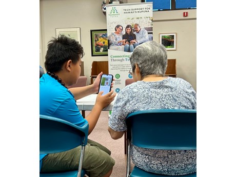 Teen helping kupuna with smart phone