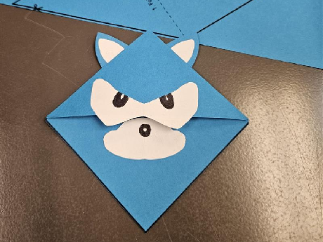 blue book corner with 2 ears, eyes, and a snoot to resemble sonic the hedgehog