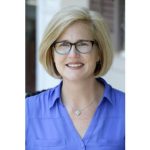 a smiling woman wearing glasses