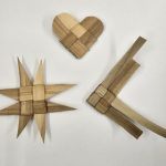 3 different shaped ornaments weaved from lau niu on a white background