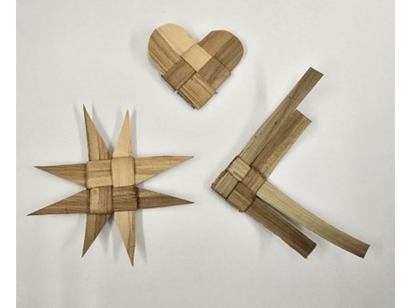 3 different shaped ornaments weaved from lau niu on a white background