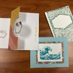 one card with dog embellishment and envelope, one blue card with stamped tidal wave, and one card with green lattice design