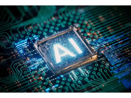 Letters AI on computer microchip, lit up, surrounded by computer motherboard parts