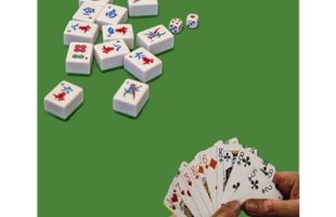 Mahjong pieces and a hand holding cards