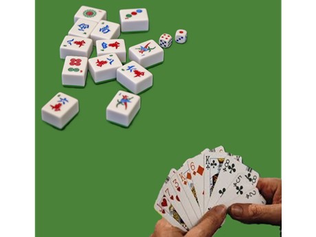 Mahjong pieces and a hand holding cards