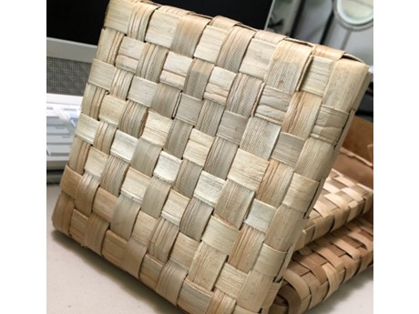 A tan hot pad woven from the lauhala plant.