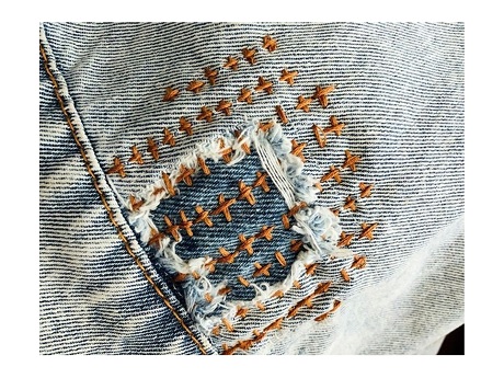 Color photo image of a mending patch on denim.