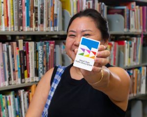 Sarah Nanbu holding a Library Card