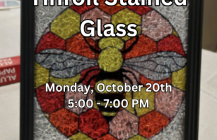 Faux stained glass picture of a bee in a black frame.