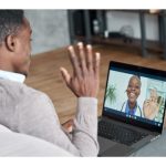 man waving at laptop screen; woman doctor waving on laptop screen