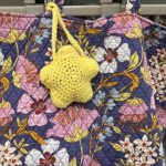 crocheted yellow star acting as tag around floral patterned bag strap