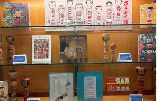display of kokeshi doll, artworks and books on the dolls